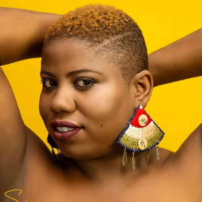 Portrait sur fond jaune avec grande boucle d'oreille