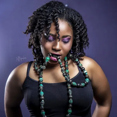 Femme portant un long collier de perles vertes et noires