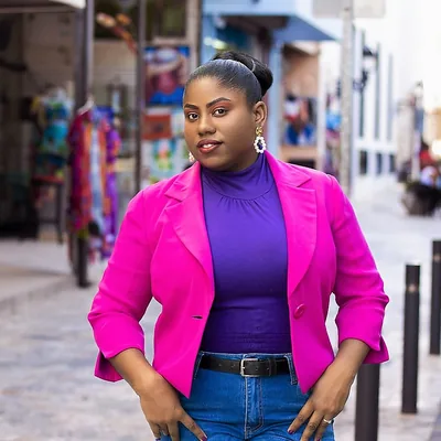 Femme en blazer rose dans une rue